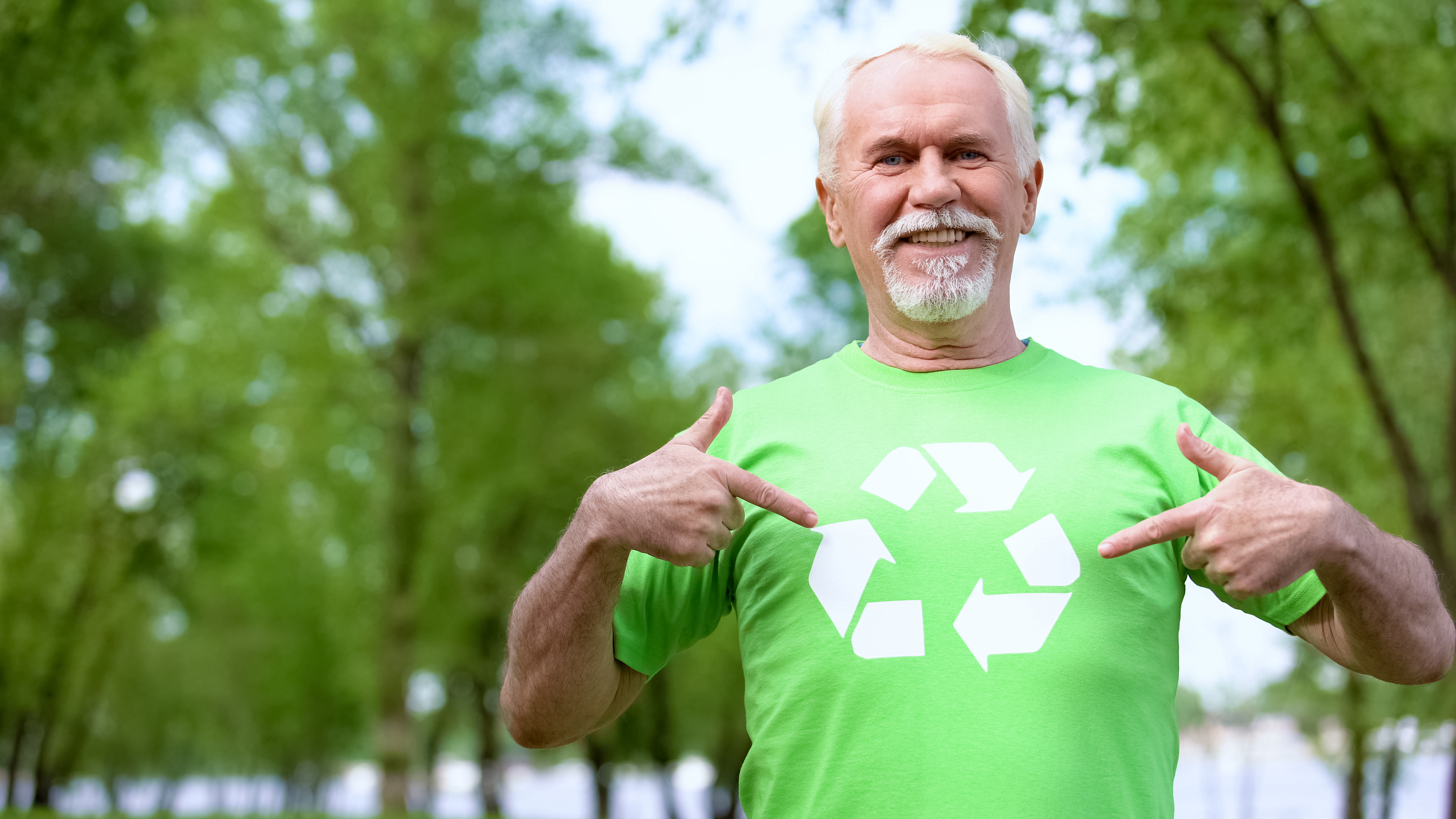 Mand peger på genbrugstrekant på sin T-shirt