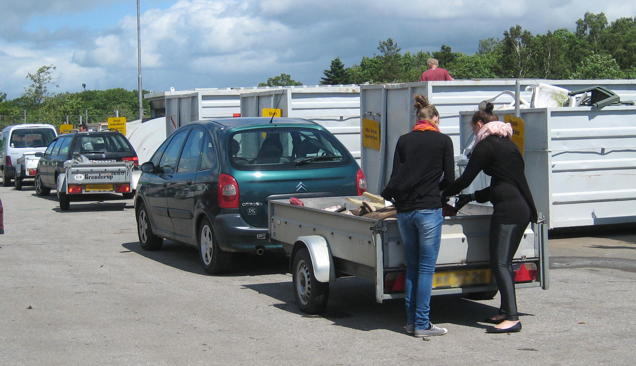 Piger tømmer trailer på genbrugspladsen