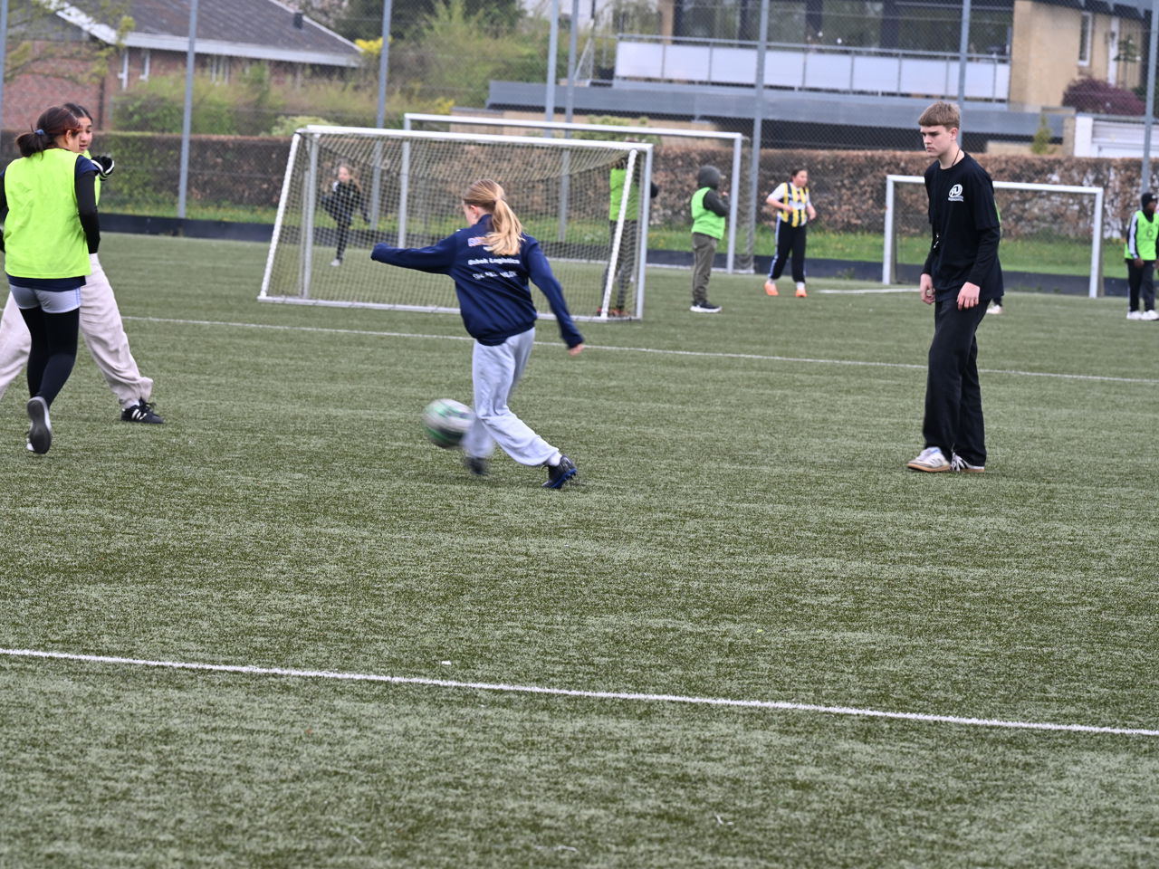 Skolebørn spiller fodbold på kunstgræsbanen ved Cepheus Park