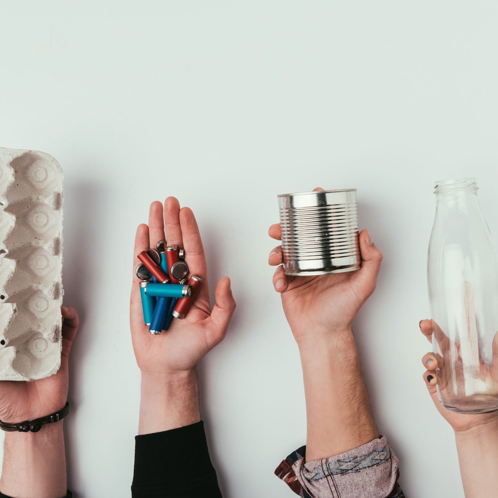 Hænder der holder forskellige slags affald